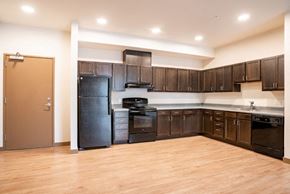 Aurora apartment for rent - Kitchen with dark brown cabinets, black appliances, grey countertop, and pot lights