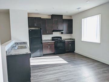 Aurora townhouse for rent - an empty kitchen with black appliances and dark wood cabinets