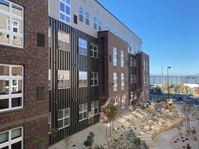 Aurora apartment for rent - a large brick building with a courtyard in front of it