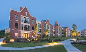 Lake Forest apartment for rent - Kelmscott Park Apartment Homes with lights at dusk