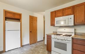 Grand Rapids apartment for rent - A kitchen with white appliances and wooden cabinets.