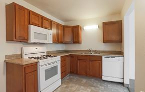 Grand Rapids apartment for rent - A kitchen with white appliances and wooden cabinets.