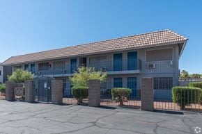 Las Vegas apartment for rent - Apartment building with a gated courtyard, trees, and bushes.