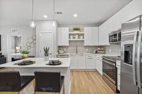 Jacksonville apartment for rent - an open kitchen and dining area with white cabinets and stainless steel appliances