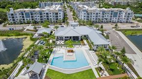 Orlando apartment for rent - an aerial view of a resort with a swimming pool and a building with palm trees