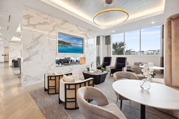 St. Petersburg apartment for rent - A modern living room with a large marble wall and a painting of a beach scene.