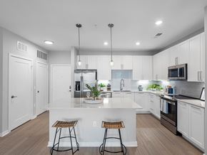 Clearwater apartment for rent - A modern kitchen with white cabinets and a central island.