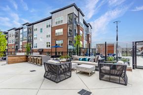 Frederick apartment for rent - an outdoor patio with furniture and an apartment building in the background
