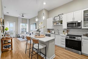 Orlando apartment for rent - A kitchen with white cabinets and a wooden floor.
