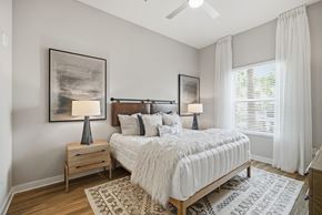 Orlando apartment for rent - A bedroom with a large bed, a nightstand with a lamp, and a rug on the floor.