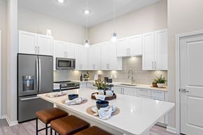 Orlando apartment for rent - A modern kitchen with white cabinets and a large island.