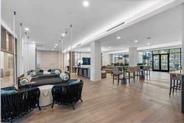 Orlando apartment for rent - A modern living room with a long black sofa and wooden floors.