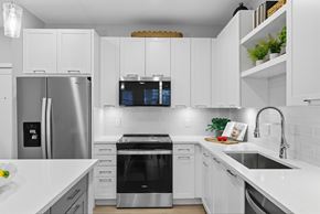 Wesley Chapel apartment for rent - A modern kitchen with white cabinets and stainless steel appliances.