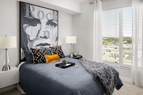 Tampa apartment for rent - a bedroom with a bed and a large picture of rock on the wall