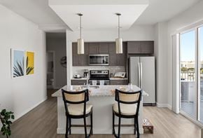 Tampa apartment for rent - a kitchen with a island with three chairs and a refrigerator