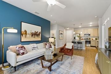 Wesley Chapel apartment for rent - A living room with a white couch and a painting of horses on the wall.