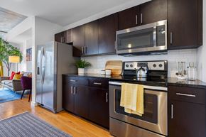 Orlando apartment for rent - A modern kitchen with dark brown cabinets and stainless steel appliances.