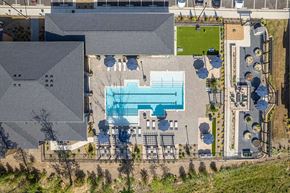 Midlothian apartment for rent - A large swimming pool is surrounded by a deck and lounge chairs.
