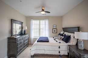 Murfreesboro apartment for rent - a bedroom with a bed and dresser and a ceiling fan