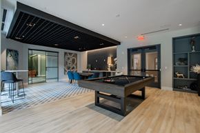 Bound Brook apartment for rent - Stylish resident lounge at The Rail at Bound Brook featuring a pool table, dining space, and modern design.