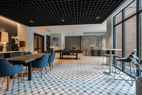 Bound Brook apartment for rent - Resident clubroom at The Rail at Bound Brook featuring a pool table, large dining table, and natural light in Bound Brook, NJ.