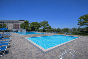 Rahway apartment for rent - A large swimming pool surrounded by blue lounge chairs.