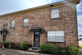 Bay City house for rent - A red brick house with a black door and windows.