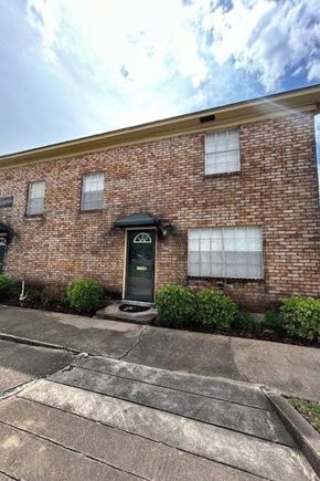 Bay City house for rent - A brick building with a black door and windows.