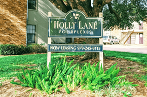 Bay City house for rent - A sign for Holly Lane Fourplexes with a phone number for leasing.