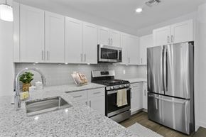 Wharton apartment for rent - A modern kitchen with a stainless steel refrigerator and a granite countertop. at 10 N. Main Apartments, New Jersey