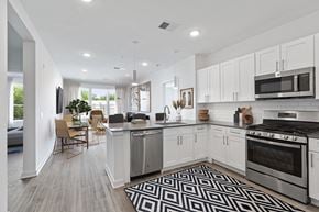 Bloomfield apartment for rent - an open kitchen and living room with white cabinets and stainless steel appliances
