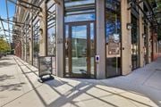 Hackensack apartment for rent - The image shows a modern building entrance with a glass door and a sign that reads "Now Open".