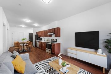 Jersey City apartment for rent - A modern living room with a grey sofa and a black television.