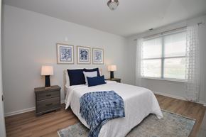 Carteret apartment for rent - A bedroom with a bed, two lamps, and a window.