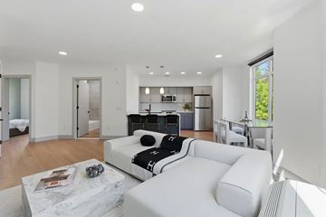 Fort Lee apartment for rent - A modern living room with a white sofa and a black and white cushion.