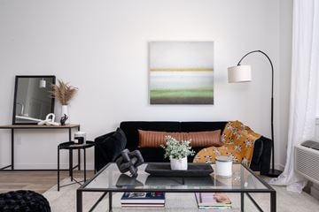 Newark apartment for rent - A living room with a black couch and a painting on the wall.
