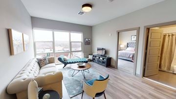 Hackensack apartment for rent - A living room with a white sofa and a blue chair.