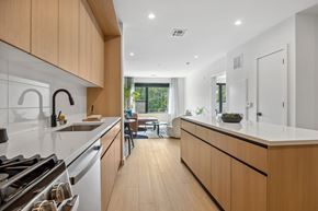 Teaneck apartment for rent - A modern kitchen with wooden cabinets and white appliances.