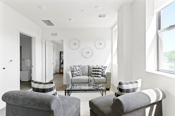 Plainfield apartment for rent - A living room with a grey couch and two grey armchairs.