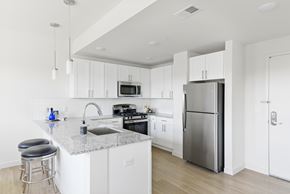 Plainfield apartment for rent - A modern kitchen with white cabinets and stainless steel appliances.