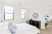 Plainfield apartment for rent - A white bedroom with a large bed and a window.