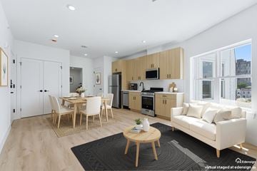 Guttenberg apartment for rent - A modern kitchen with wooden cabinets and a dining table with chairs.