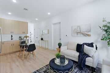 Guttenberg apartment for rent - A modern living room with a white couch and a black and white rug.