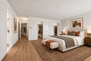 Arlington apartment for rent - A bedroom with a large bed and a bench in front of it.