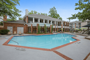 Woodbridge apartment for rent - A pool surrounded by a brick building and trees.