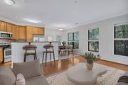 Lorton apartment for rent - A modern kitchen with wooden cabinets and a dining area with a table and chairs.
