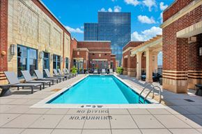 Arlington apartment for rent - A pool surrounded by brick buildings with a sign that says