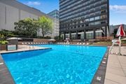 Arlington apartment for rent - A large blue swimming pool in front of a building.