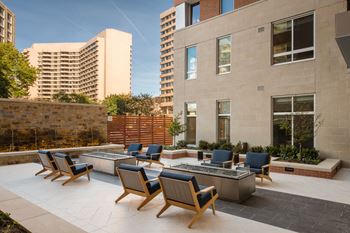 Courtyard with outdoor fireplaces, landscaping, and elegant water feature 
