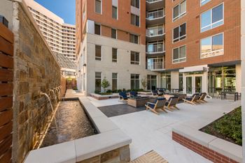 Courtyard with outdoor fireplaces, landscaping, and elegant water feature 